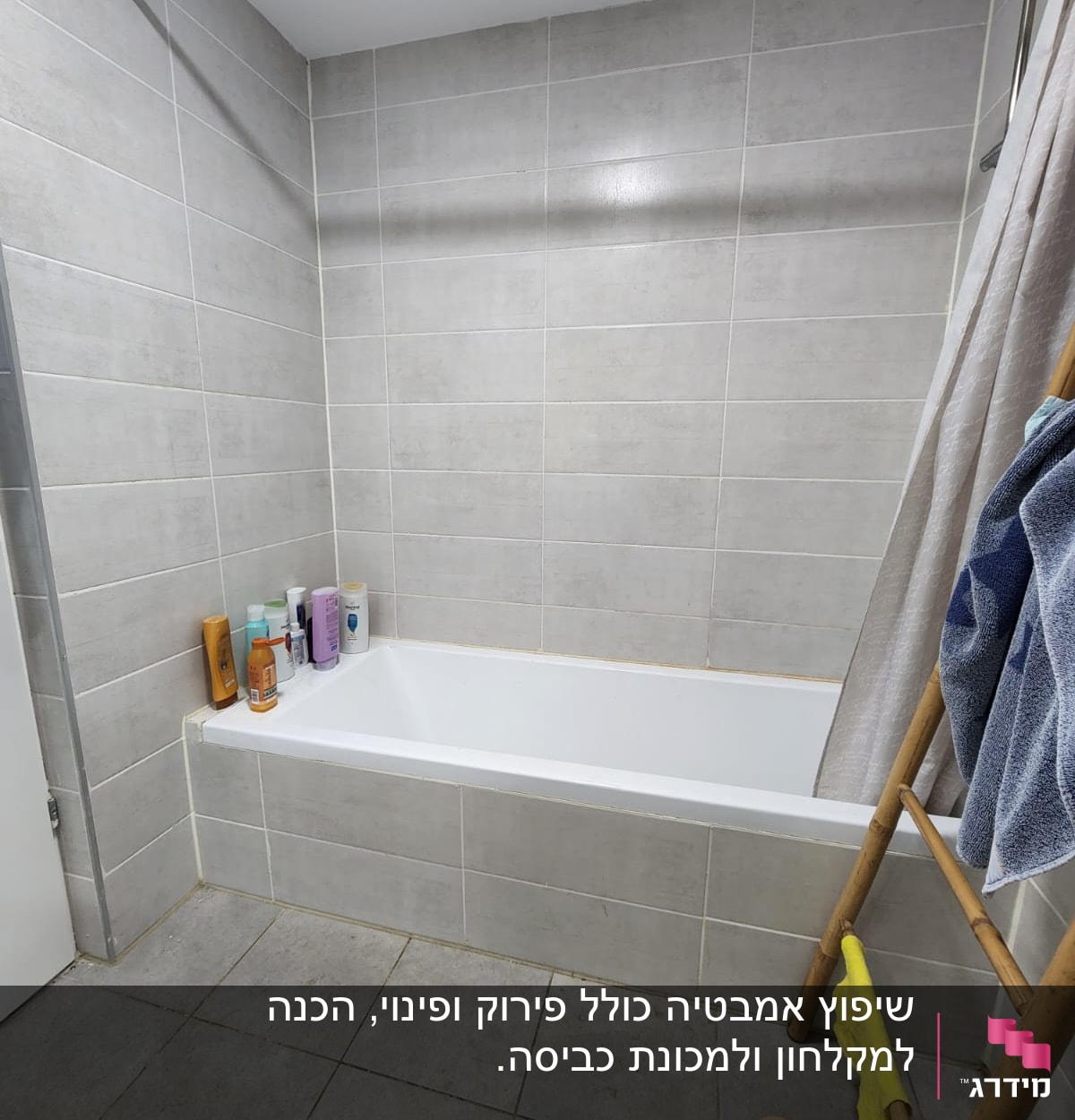 חדר אמבטיה עם אריחים אפורים ואמבטיה לבנה